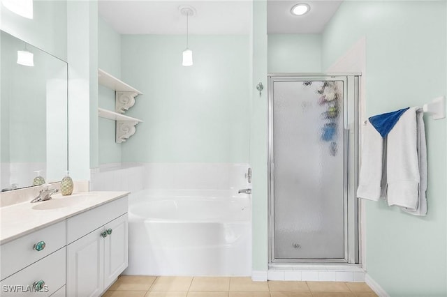 bathroom featuring a stall shower, vanity, a garden tub, and tile patterned floors