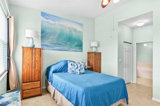 tiled bedroom with connected bathroom and ceiling fan