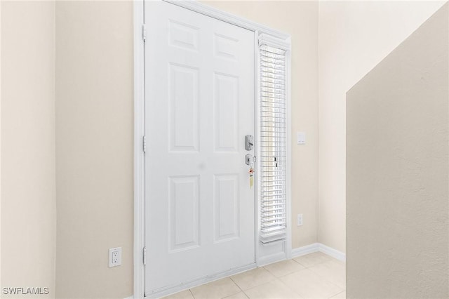 foyer entrance with light tile patterned floors and baseboards