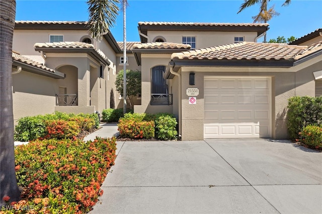 21551 Pelican Sound Dr Unit 202, Estero, FL 33928 - mediterranean / spanish-style house with driveway, a garage, stucco siding, and a tile roof