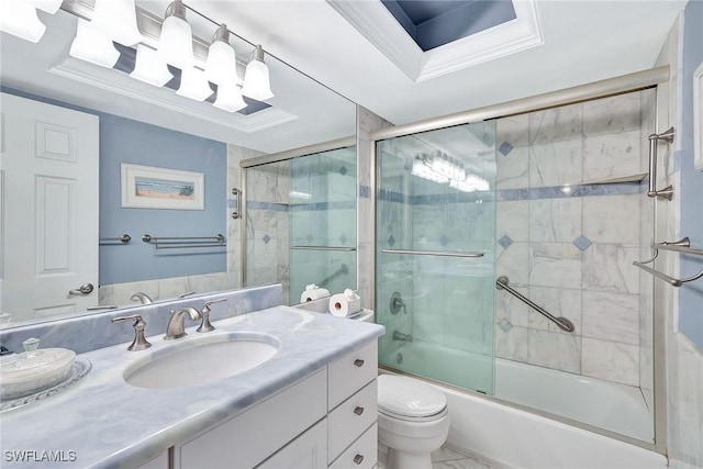 bathroom with a raised ceiling, vanity, enclosed tub / shower combo, and toilet