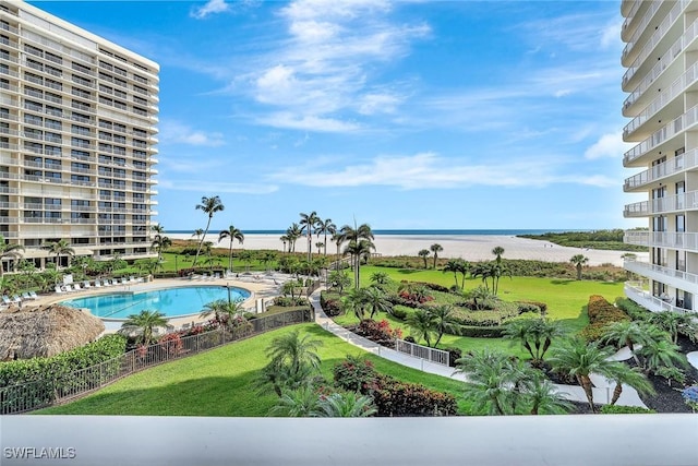 community pool with a water view and a yard