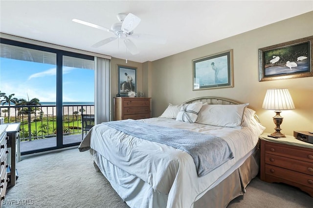 bedroom featuring light colored carpet, access to exterior, ceiling fan, and a wall of windows