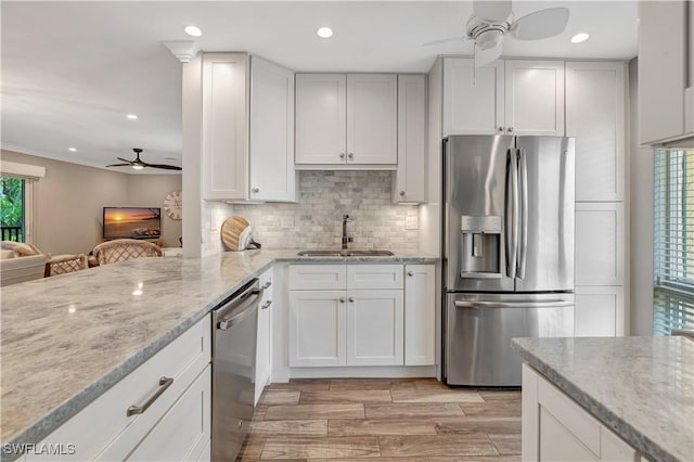 300 Palm Dr Unit 402, Naples, FL 34112 - kitchen with stainless steel appliances, a ceiling fan, a sink, decorative backsplash, and light stone counters