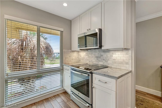 300 Palm Dr Unit 402, Naples, FL 34112 - kitchen featuring stainless steel appliances, white cabinets, decorative backsplash, baseboards, and recessed lighting