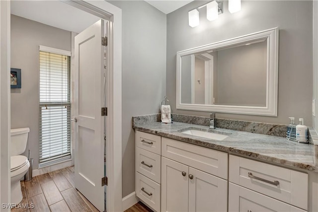 300 Palm Dr Unit 402, Naples, FL 34112 - bathroom featuring toilet, vanity, baseboards, and plenty of natural light