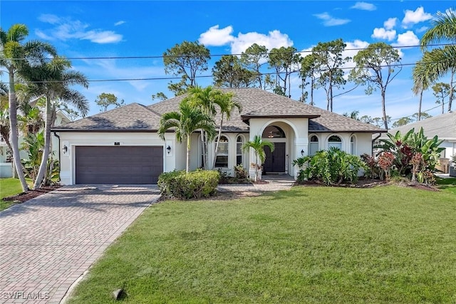 1302 SW 20th St, Cape Coral, FL 33991 - view of front of house featuring decorative driveway, a garage, a front yard, and stucco siding