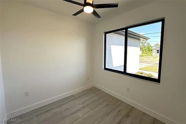unfurnished room featuring light wood-style flooring, baseboards, and a ceiling fan