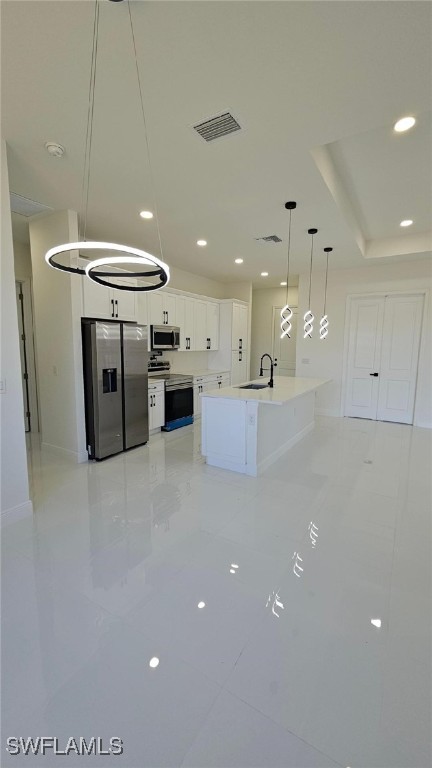 449 Redwing St, Lehigh Acres, FL 33974 - kitchen with stainless steel appliances, a sink, white cabinetry, light tile patterned floors, and recessed lighting