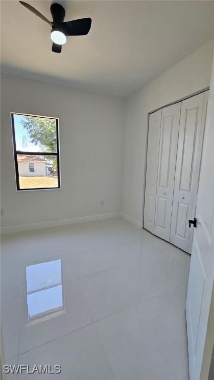 449 Redwing St, Lehigh Acres, FL 33974 - unfurnished bedroom with light tile patterned flooring, a closet, baseboards, and ceiling fan