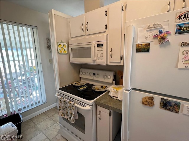 22147 Catherine Ave, Port Charlotte, FL 33952 - kitchen with white appliances, white cabinetry, dark countertops, and baseboards