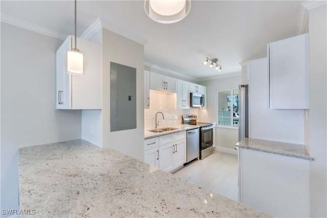 kitchen with stainless steel appliances, electric panel, ornamental molding, a sink, and white cabinets