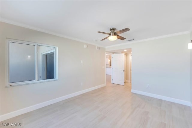 spare room featuring crown molding, baseboards, light wood-style flooring, and a ceiling fan