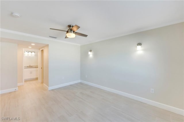 empty room with ornamental molding, ceiling fan, baseboards, light wood finished floors, and a smoke detector
