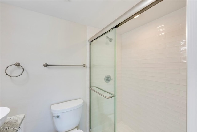 full bath featuring a shower stall and toilet