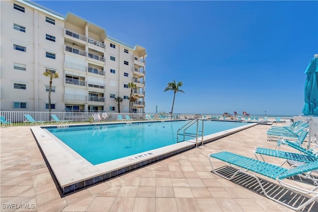 community pool featuring fence and a patio