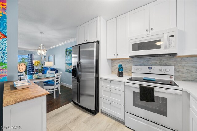 190 Turtle Lake Ct Unit 311, Naples, FL 34105 - kitchen featuring white appliances, light countertops, light wood finished floors, white cabinets, and tasteful backsplash