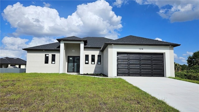 1214 Hibiscus Ave, Lehigh Acres, FL 33972 - prairie-style home with stucco siding, an attached garage, driveway, a front yard, and a shingled roof