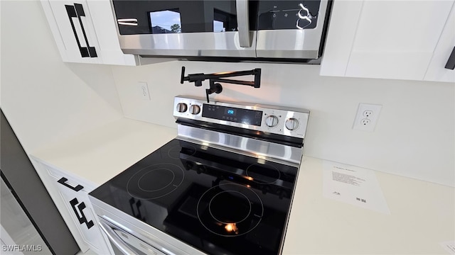 1214 Hibiscus Ave, Lehigh Acres, FL 33972 - detailed view of appliances with stainless steel finishes, white cabinetry, and light countertops