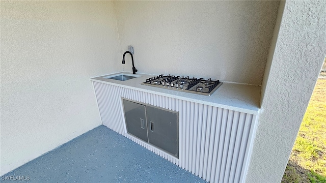 1214 Hibiscus Ave, Lehigh Acres, FL 33972 - detailed view of a textured wall, stainless steel gas cooktop, and a sink