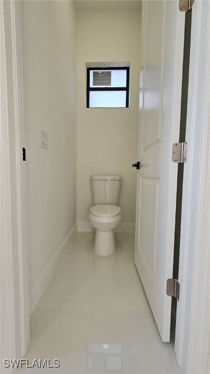 1214 Hibiscus Ave, Lehigh Acres, FL 33972 - bathroom with toilet, baseboards, and tile patterned floors