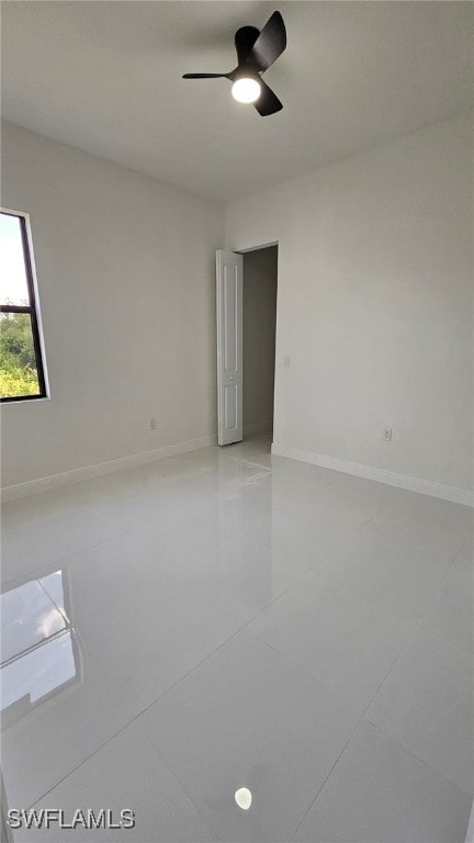 1214 Hibiscus Ave, Lehigh Acres, FL 33972 - spare room featuring light tile patterned flooring, ceiling fan, and baseboards