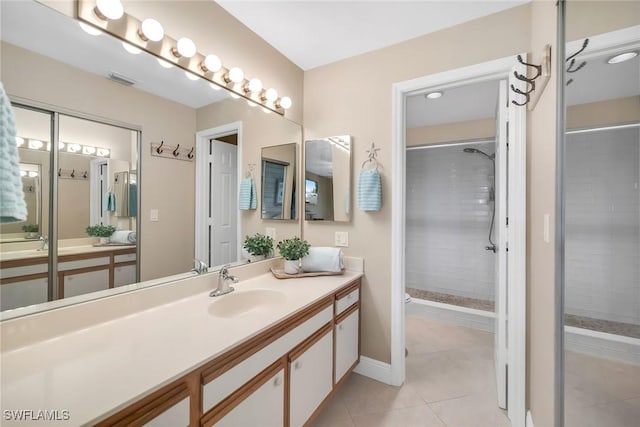 676 W Elkcam Cir Unit 1222, Marco Island, FL 34145 - bathroom featuring a tile shower, tile patterned flooring, vanity, and baseboards