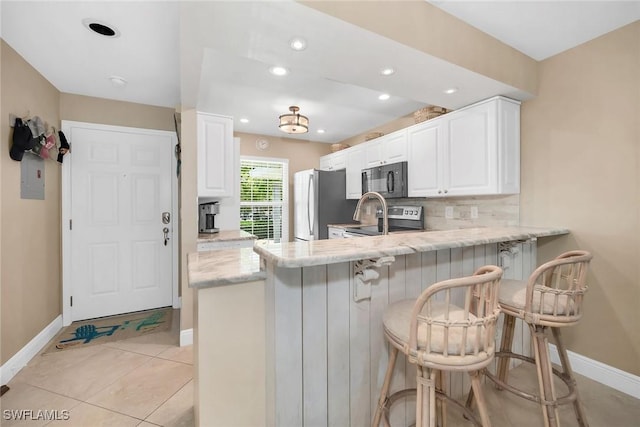 676 W Elkcam Cir Unit 1222, Marco Island, FL 34145 - kitchen with appliances with stainless steel finishes, baseboards, a peninsula, white cabinetry, and recessed lighting