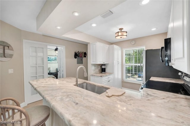 676 W Elkcam Cir Unit 1222, Marco Island, FL 34145 - kitchen featuring a sink, stainless steel range with electric cooktop, white cabinets, light stone countertops, and baseboards