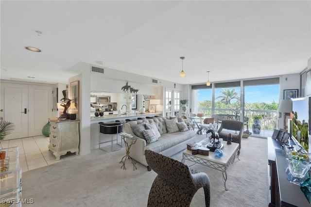 6573 Marissa Loop Unit 303, Naples, FL 34108 - living room featuring light tile patterned flooring and expansive windows