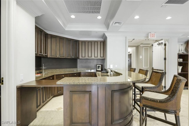 2745 1st St Unit 701, Fort Myers, FL 33916 - kitchen featuring light tile patterned flooring, ornamental molding, a breakfast bar, a peninsula, and recessed lighting