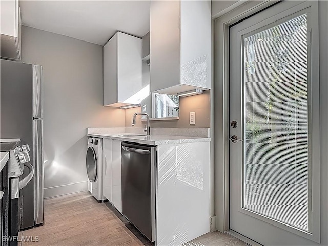 2544 1st St Unit 102, Fort Myers, FL 33901 - kitchen featuring stainless steel appliances, light countertops, a sink, white cabinets, and baseboards