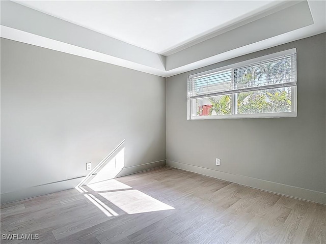2544 1st St Unit 102, Fort Myers, FL 33901 - unfurnished room with light wood finished floors, baseboards, and a raised ceiling
