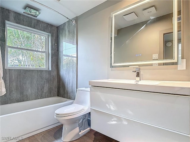 2544 1st St Unit 102, Fort Myers, FL 33901 - bathroom with toilet, wood finished floors, vanity, and washtub / shower combination
