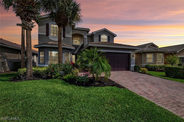 6619 Marbella Dr, Naples, FL 34105 - view of front of home featuring stucco siding, decorative driveway, an attached garage, a yard, and a tile roof