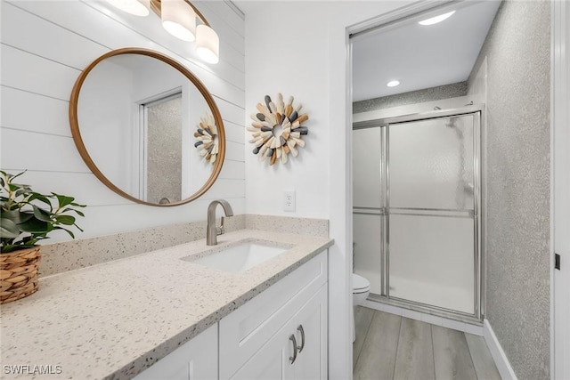 9087 Michael Cir Unit 9, Naples, FL 34113 - bathroom with a stall shower, vanity, wood finished floors, toilet, and recessed lighting