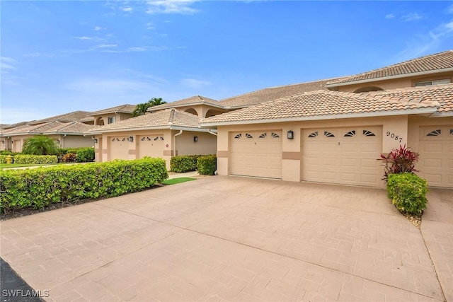 9087 Michael Cir Unit 9, Naples, FL 34113 - view of front of house featuring a tile roof, stucco siding, driveway, and an attached garage