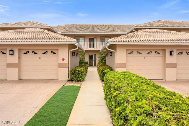 9087 Michael Cir Unit 9, Naples, FL 34113 - view of front of home with stucco siding, a tiled roof, driveway, and a garage