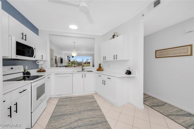 9087 Michael Cir Unit 9, Naples, FL 34113 - kitchen featuring white appliances, a sink, light countertops, light tile patterned floors, and white cabinetry
