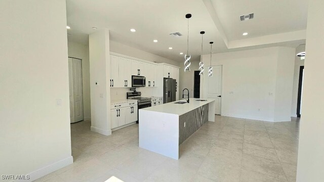 1019 Calvin Ave, Lehigh Acres, FL 33972 - kitchen featuring stainless steel appliances, a sink, a center island with sink, white cabinetry, and baseboards