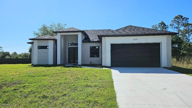 1019 Calvin Ave, Lehigh Acres, FL 33972 - view of front of property with stucco siding, an attached garage, concrete driveway, and a front lawn