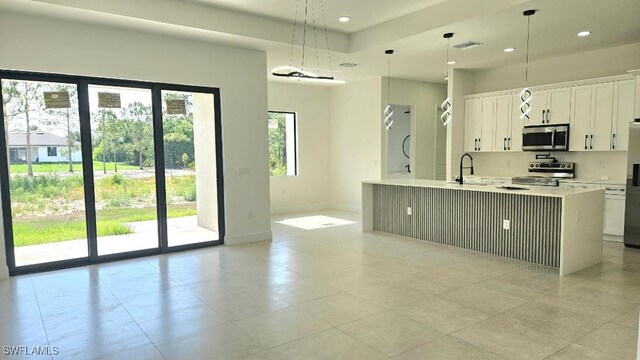 1019 Calvin Ave, Lehigh Acres, FL 33972 - kitchen featuring stainless steel appliances, light countertops, baseboards, white cabinets, and recessed lighting