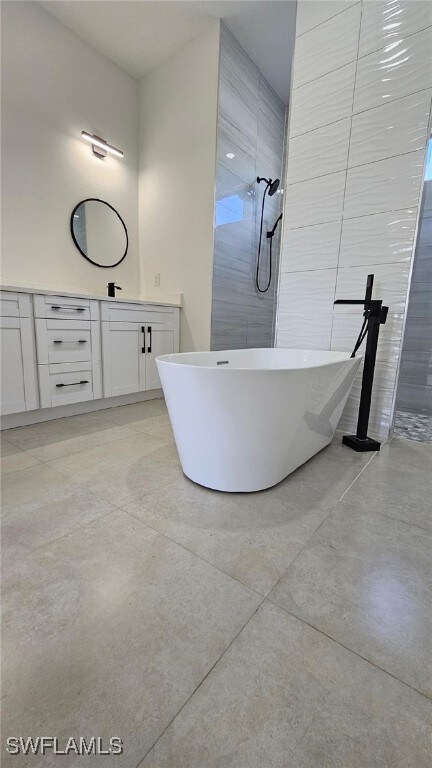 1019 Calvin Ave, Lehigh Acres, FL 33972 - full bathroom with a soaking tub, vanity, a tile shower, and concrete flooring