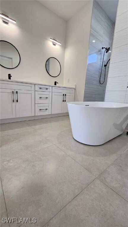 1019 Calvin Ave, Lehigh Acres, FL 33972 - bathroom featuring a soaking tub, a tile shower, double vanity, and concrete floors