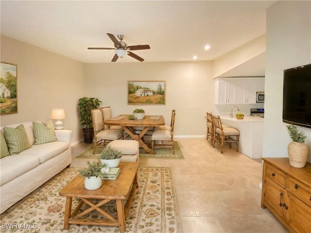 living area featuring ceiling fan, baseboards, and recessed lighting