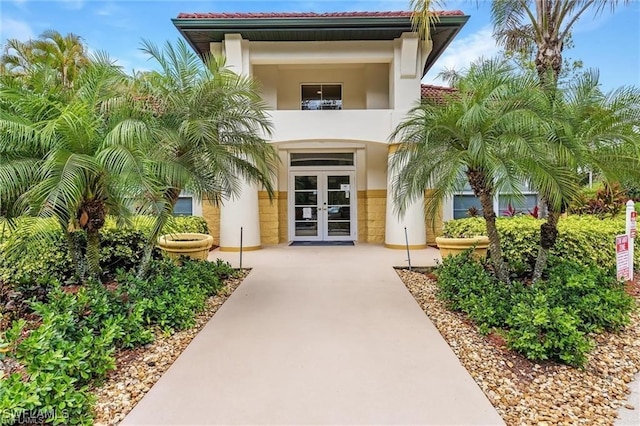 doorway to property featuring french doors and stucco siding