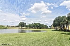 surrounding community with a water view and a lawn