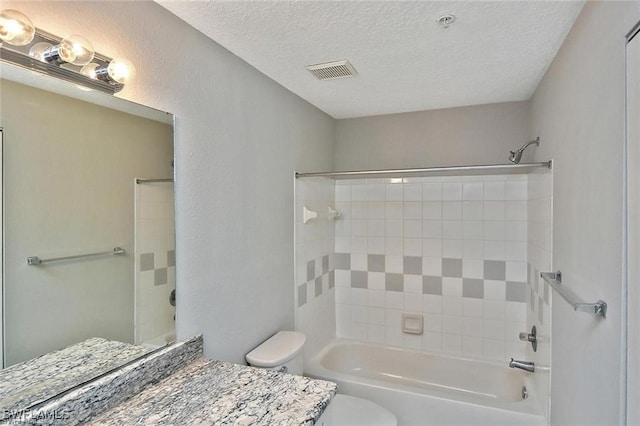 bathroom featuring toilet, washtub / shower combination, vanity, and a textured ceiling