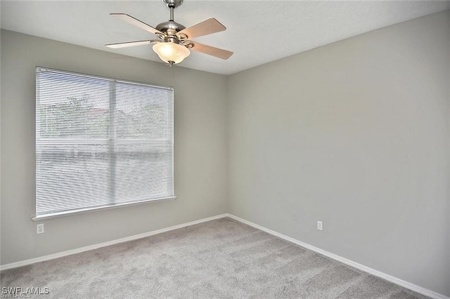 unfurnished room featuring carpet floors, ceiling fan, and baseboards