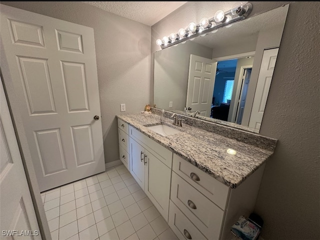 11510 Villa Grand Unit 404, Fort Myers, FL 33913 - bathroom with tile patterned flooring, a textured ceiling, vanity, and a textured wall